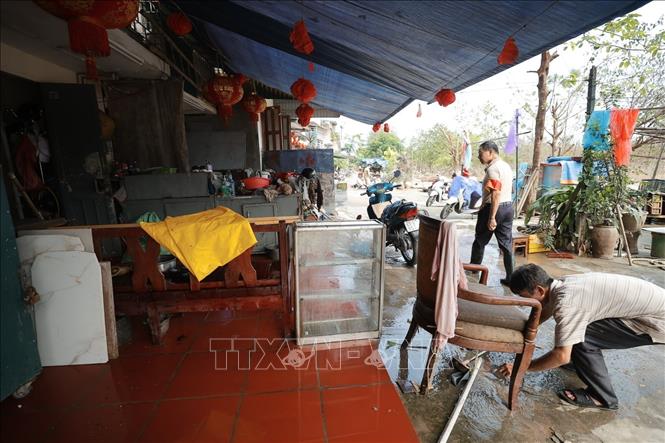 Người dân phường Phúc Tân, quận Hoàn Kiếm dọn dẹp vệ sinh nhà cửa sau khi nước rút (ảnh chụp lúc 10 giờ 5 phút).  Ảnh: Minh Quyết - TTXVN