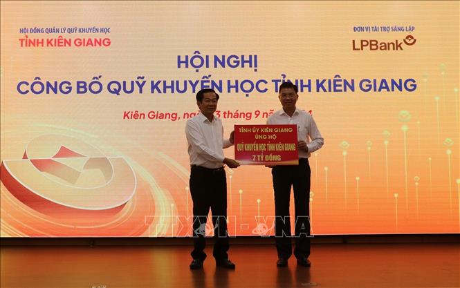 Bí thư Tỉnh ủy Kiên Giang Đỗ Thanh Bình (trái) trao bảng tượng trưng ủng hộ Quỹ Khuyến học tỉnh. Ảnh:
Lê Huy Hải - TTXVN