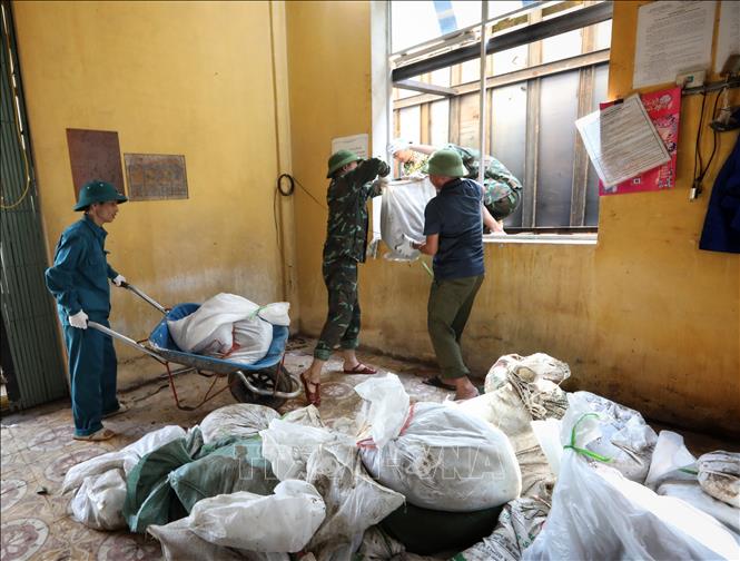 Lực lượng Ban Chỉ huy quân sự thành phố Bắc Giang tham gia gia cố bể xả Trạm bơm Cống Bún. Ảnh: Danh Lam -TTXVN 