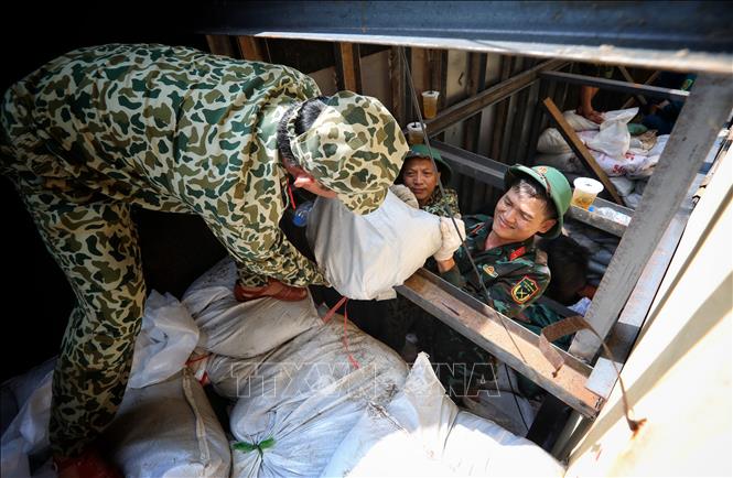 Lực lượng Ban Chỉ huy quân sự thành phố Bắc Giang tham gia gia cố bể xả Trạm bơm Cống Bún. Ảnh: Danh Lam -TTXVN 
