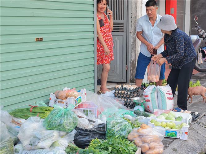 Một hàng rau đã bày bán, phục vụ khách hàng sau khi nước rút trên phố Bạch Đằng. Ảnh: Hoàng Hiếu - TTXVN