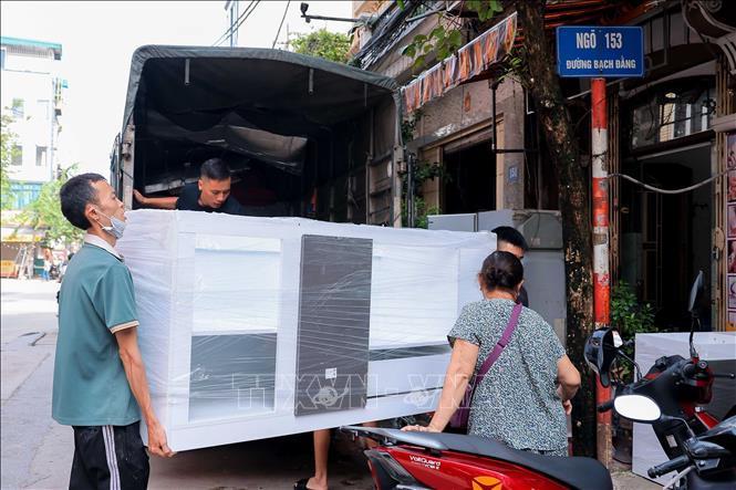 Một gia đình trên đường Bạch Đằng mua đồ đạc thay thế đồ đạc bị hư hỏng do nước ngập. Ảnh: Hoàng Hiếu - TTXVN