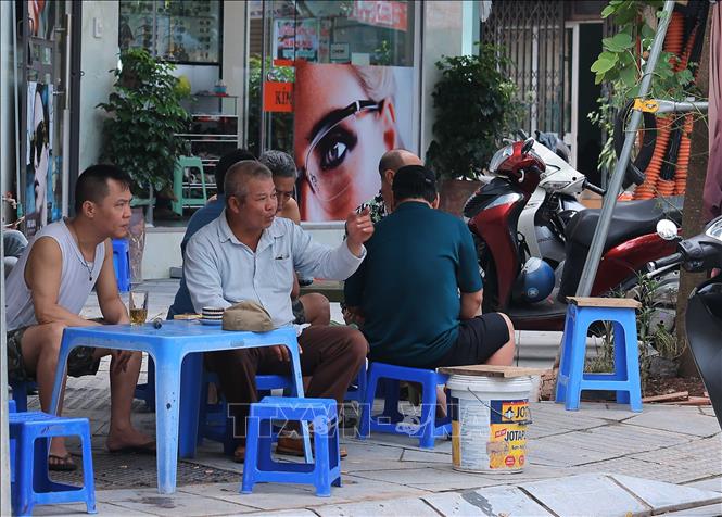 Hàng quán ven đường đã mở trở lại để cư dân ngồi hàn huyện câu chuyện lũ lụt. Ảnh: Hoàng Hiếu - TTXVN