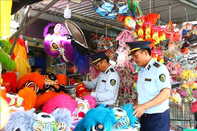 Cán bộ Cục Quản lý thị trường tỉnh Quảng Bình kiểm tra các mặt hàng đồ chơi dịp Tết Trung thu. Ảnh: Tá Chuyên - TTXVN