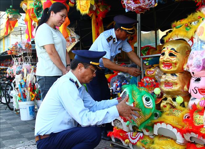Cán bộ Cục Quản lý thị trường tỉnh Quảng Bình kiểm tra các mặt hàng đồ chơi dịp Tết Trung thu. Ảnh: Tá Chuyên - TTXVN