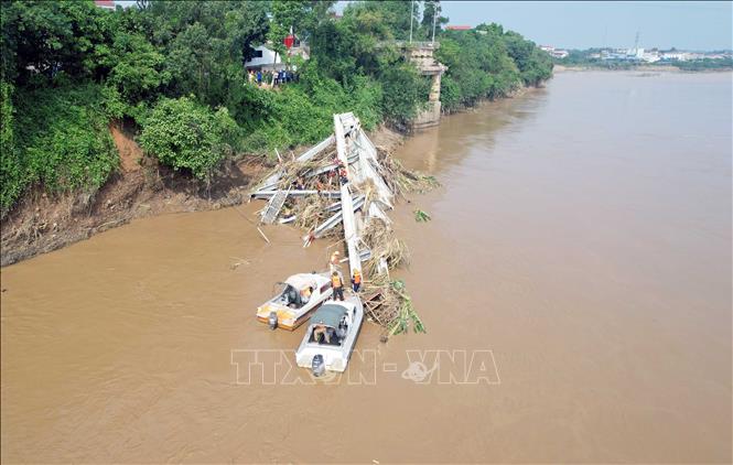 Các lực lượng chức năng tiếp tục tiếp cận nhịp cầu bị sập để có phương án trục vớt, đồng thời tìm kiếm những nạn nhân đang bị mất tích. Ảnh: Tạ Toàn - TTXVN