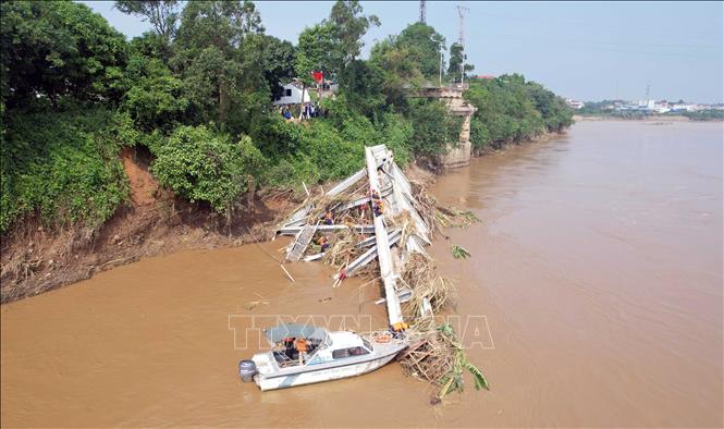 Các lực lượng chức năng tiếp tục tiếp cận nhịp cầu bị sập để có phương án trục vớt, đồng thời tìm kiếm những nạn nhân đang bị mất tích. Ảnh: Tạ Toàn - TTXVN