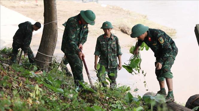 Các lực lượng chức năng đang dọn dẹp lối lên xuống để chuẩn bị lắp đặt cầu phao khi điều kiện cho phép. Ảnh: Tạ Toàn - TTXVN