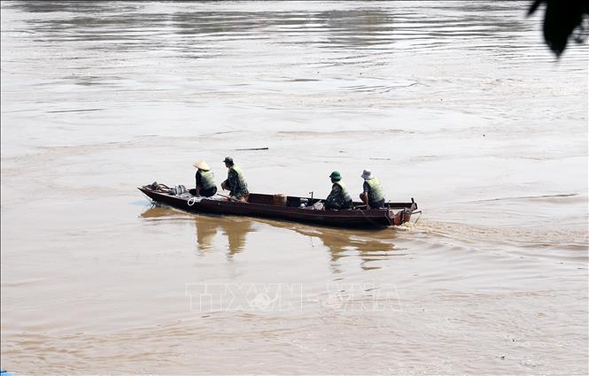 Lực lượng quân đội tiến hành khảo sát mực nước sông, đánh giá dòng chảy để chuẩn bị lắp đặt cầu phao khi điều kiện cho phép. Ảnh: Tạ Toàn - TTXVN