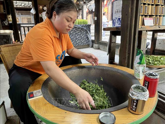 Nghề sao chè thủ công truyền thống của người Thổ Gia. Ảnh: Công Tuyên-P/v TTXVN tại Trung Quốc