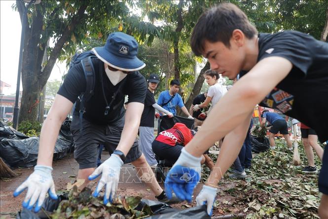 Tình nguyện viên cùng chung tay dọn dẹp, vệ sinh môi trường, khắc phục hậu quả bão số 3 tại khu vực quận Hoàn Kiếm. Ảnh: Minh Quyết - TTXVN
