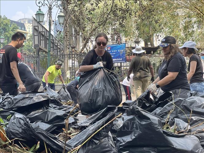 Tình nguyện viên chung tay dọn dẹp vệ sinh khu vực cạnh Quảng trường Cách mạng tháng Tám. Ảnh: Minh Quyết - TTXVN