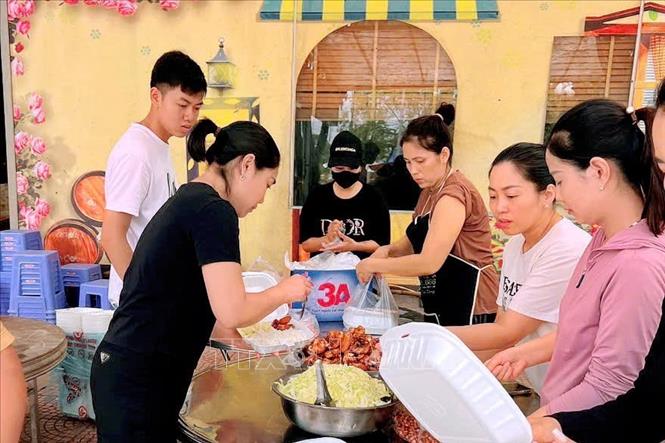 Nhân viên chuỗi cửa hàng hoa quả sạch Chuối béo thị xã Đông Triều chuẩn bị các suất cơm để trao đến tay đồng bào bị lũ. Ảnh: Lê Đại/TTXVN phát
