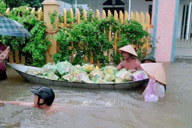 Nhà hảo tâm mang cơm, nước lọc đến phát cho các hộ dân bị ngập tại xã Nguyễn Huệ, thị xã Đông Triều. Ảnh: Lê Đại/TTXVN phát