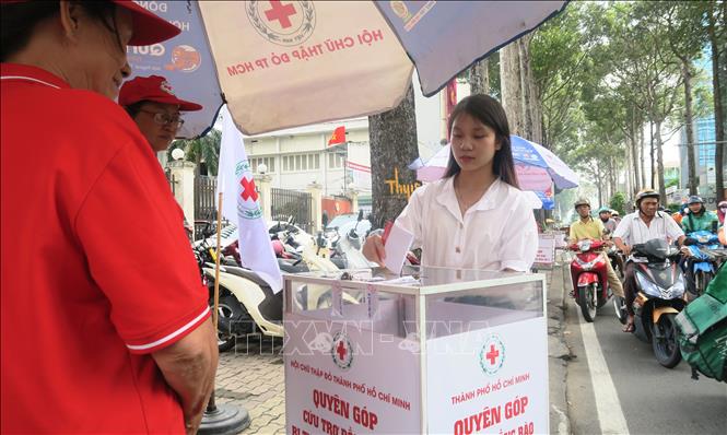 Người dân Thành phố Hồ Chí Minh góp tiền vào thùng cứu trợ gửi đến đồng bào vùng lũ. Ảnh: Đinh Hằng - TTXVN 