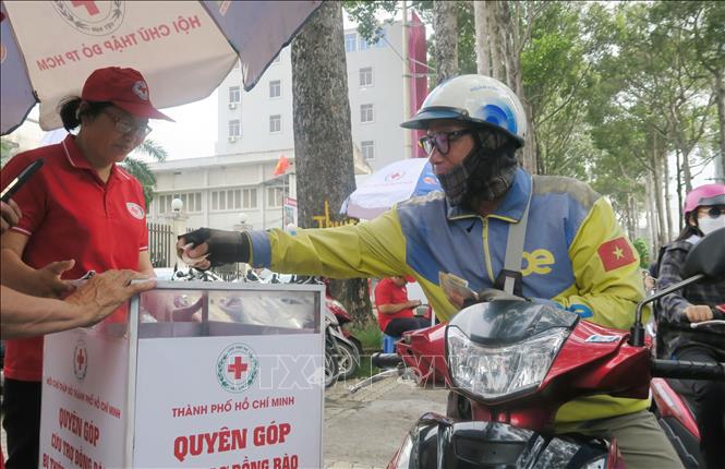 Một tài xế xe công nghệ gửi hỗ trợ đồng bào bị thiên tai thông qua Hội Chữ thập đỏ Thành phố Hồ Chí Minh. Ảnh: Đinh Hằng - TTXVN 