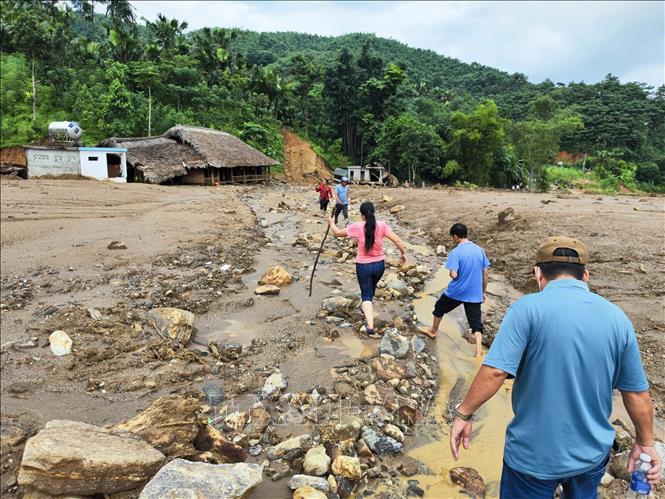 Việc di chuyển đến các ngôi nhà gần núi Voi bị hư hỏng do lũ cuốn gặp rất nhiều khó khăn. Ảnh: Nam Sương - TTXVN 