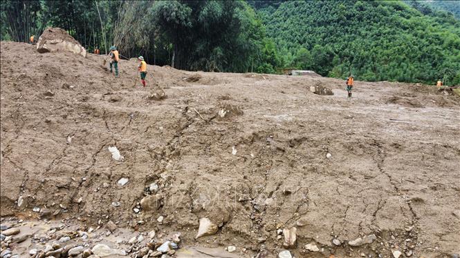 Bùn dâng cao và đang khô dần do nắng lên khiến việc tìm kiếm nạn nhân gần núi Voi gặp rất nhiều khó khăn. Ảnh: Hoàng Hiếu - TTXVN