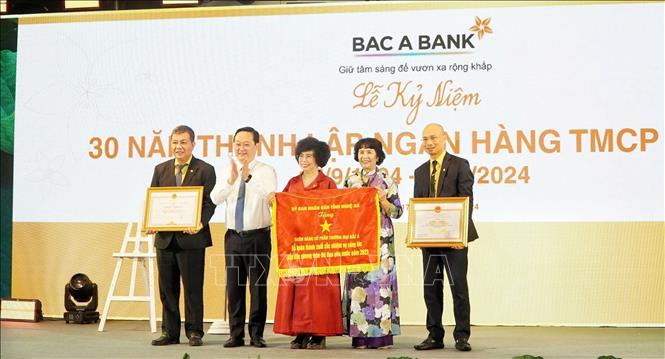 Chủ tịch UBND tỉnh Nghệ An tặng cờ thi đua xuất sắc cho Ngân hàng TMCP Bắc Á. Ảnh: Trịnh Duy Hưng-TTXVN