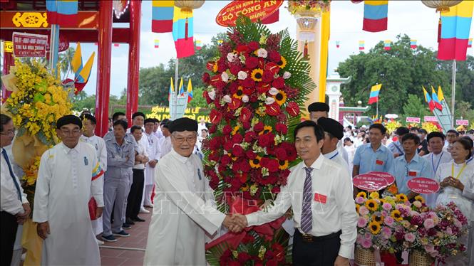 Ông Nguyễn Ánh Chức, Phó trưởng Ban Tôn giáo Chính phủ (bên phải) đại diện tặng hoa của Bộ Công an chúc mừng Đại lễ Hội yến Diêu Trì Cung. Ảnh: Minh Phú – TTXVN