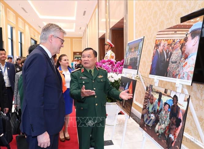 Thứ trưởng Bộ Quốc phòng Hoàng Xuân Chiến và Phó Tổng Thư ký LHQ Jean-Pierre Lacroix cùng các đại biểu xem triển lãm ảnh về phụ nữ với hoạt động gìn giữ hòa bình LHQ tại Hội nghị quốc tế về Phụ nữ với hoạt động gìn giữ hòa bình Liên hợp quốc (2022). Ảnh: Trọng Đức - TTXVN