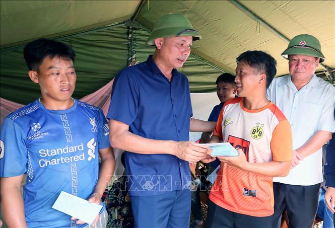 Phó Chủ tịch UBND tỉnh Sơn La Nguyễn Thành Công và lãnh đạo huyện Mường La đến thăm hỏi, động viên, trao quà cho nhân dân bản Nà Chà, xã Pi Toong tại nơi ở tạm. Ảnh: Quang Quyết - TTXVN