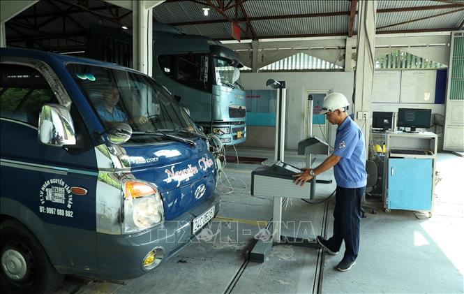 Các đăng kiểm viên kiểm tra phương tiện tại Trung tâm đăng kiểm 2401D. Ảnh: Quốc Khánh - TTXVN