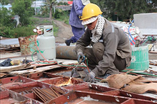 Công nhân đang thi công mặt cầu cho đơn nguyên bên phải của cầu An Thạnh thuộc dự án Đường tỉnh 830E, đoạn từ nút giao ĐT.830 đến đường Nguyễn Văn Nhâm. Ảnh: Minh Hưng - TTXVN