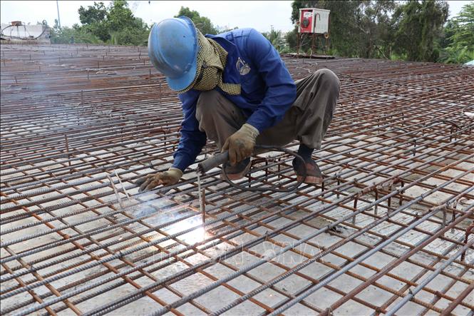 Công nhân thi công mặt cầu cho đơn nguyên bên phải của cầu An Thạnh thuộc dự án Đường tỉnh 830E, đoạn từ nút giao ĐT.830 đến đường Nguyễn Văn Nhâm. Ảnh: Minh Hưng - TTXVN