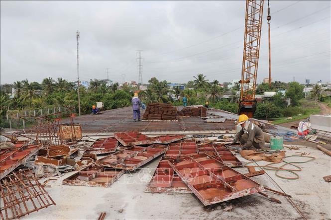 Công nhân làm mặt cầu cho đơn nguyên bên phải của cầu An Thạnh thuộc dự án Đường tỉnh 830E, đoạn từ nút giao ĐT.830 đến đường Nguyễn Văn Nhâm. Ảnh: Minh Hưng - TTXVN