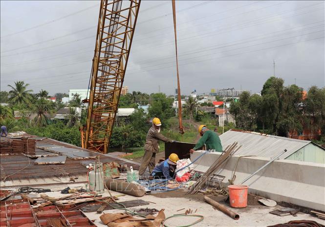 Công nhân làm lan can cho đơn nguyên bên phải của cầu An Thạnh thuộc dự án Đường tỉnh 830E, đoạn từ nút giao ĐT.830 đến đường Nguyễn Văn Nhâm. Ảnh: Minh Hưng - TTXVN
