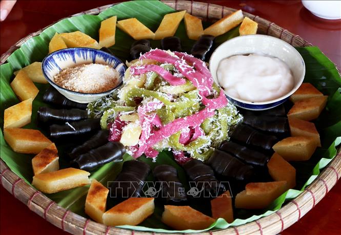 A combined dish of local cakes made from rice flour and cassava flour, which includes: banh tam bi (steamed rice cake with coconut), banh khoai mi nuoc (steamed cassava cake with coconut) and banh la rau mo (steamed black rice cake). VNA Photo: Hồng Đạt