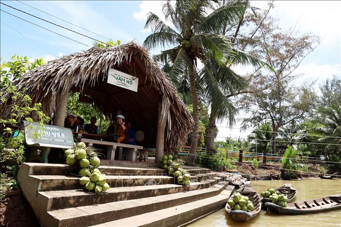 Tourists enjoy traditional view of Ben Tre rural area with boats, a bamboo shed and coconut trees in the summer sun. VNA Photo: Hồng Đạt