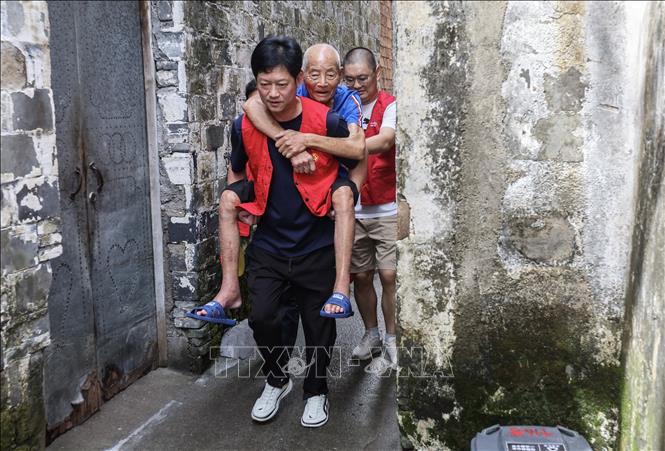 Tình nguyện viên hỗ trợ người dân sơ tán tránh bão Pulasan tại tỉnh Chiết Giang, Trung Quốc, ngày 19/9/2024. Ảnh: THX/TTXVN