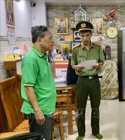 Cơ quan điều tra Công an Thành phố Hồ Chí Minh tống đạt các quyết định và lệnh đối tượng Trần Văn Linh. Ảnh: TTXVN phát 
