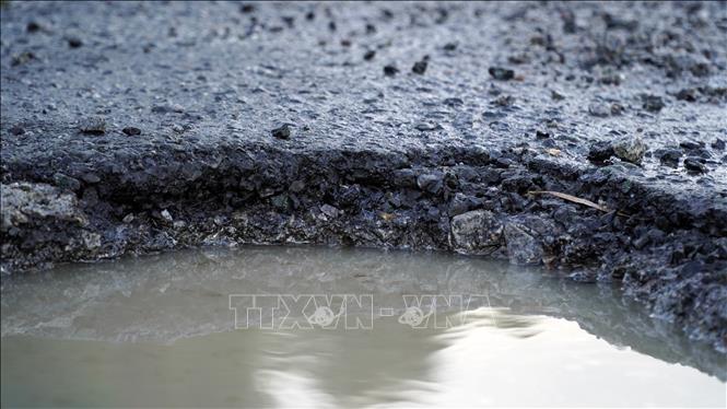 Quốc lộ 61 qua tỉnh Kiên Giang có những chỗ hư hỏng nặng tạo hố sâu khoảng 15cm, dễ gây tai nạn cho người lái xe. Ảnh: Văn Sĩ - TTXVN                                       