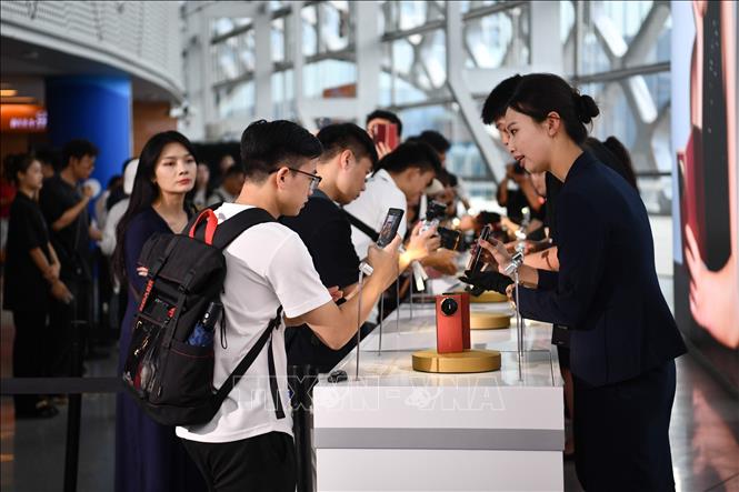 Khách hàng trải nghiệm điện thoại của Huawei tại Thâm Quyến, tỉnh Quảng Đông, Trung Quốc. Ảnh: THX/TTXVN