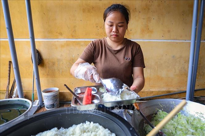 Chị Xa Thị Thanh – Trưởng nhóm chi hội phụ nữ xóm Sơn Phú tất bật chuẩn bị bữa trưa cho học sinh xóm Rằng. Ảnh: Trọng Đạt-TTXVN