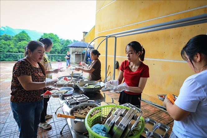 Thành viên của Chi hội phụ nữ Sơn Phú mỗi người một việc tất bật chuẩn bị bữa trưa cho các học sinh xóm Rằng tại chi trường Sơn Phú. Ảnh: Trọng Đạt-TTXVN