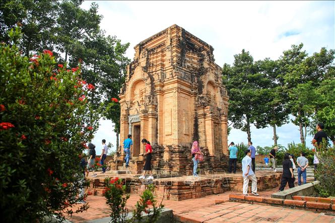 Du khách tìm hiểu kiến trúc tháp Chót Mạt. Ảnh: Giang Phương - TTXVN