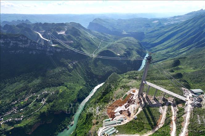 Dự kiến sau khi khánh thành đưa vào vận hành giữa năm 2025, cầu Hẻm núi Hoa Giang sẽ lập kỷ lục thế giới mới với độ cao 625 mét, với nhịp chính cũng dài nhất thế giới, hơn 1.420 mét. Ảnh: TTXVN phát