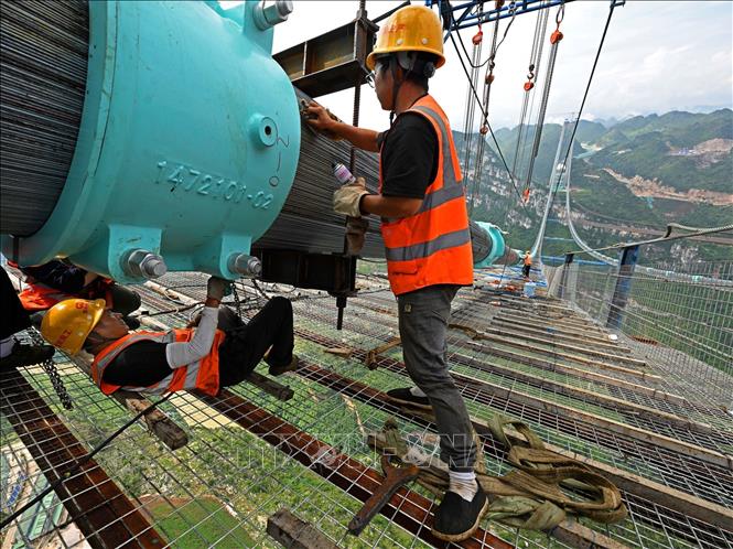 Trong bó cáp treo được tích hợp sợi cáp thông minh với công nghệ tiên tiến nhất, đươc gọi “dây thần kinh” giám sát, theo dõi “sức khỏe” của cầu. Ảnh: TTXVN phát