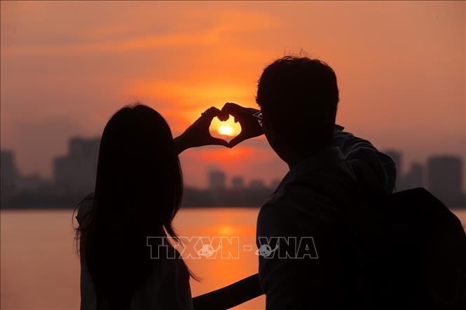 Đôi bạn trẻ tận hưởng cảnh sắc mùa Thu Hà Nội đầy lãng mạn. Ảnh: Minh Quyết - TTXVN