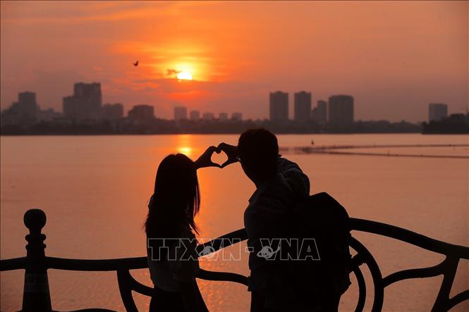 Đôi bạn trẻ tận hưởng cảnh sắc mùa Thu Hà Nội đầy lãng mạn. Ảnh: Minh Quyết - TTXVN