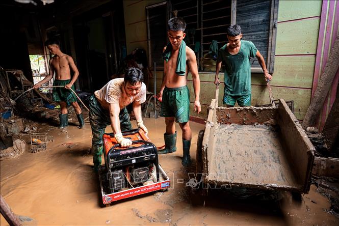 Chiến sĩ Sư đoàn 316 giúp người dân xã Phúc Khánh, huyện Bảo Yên dọp dẹp nhà cửa sau lũ. Ảnh: Hoàng Hiếu - TTXVN