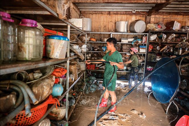 Chiến sĩ Sư đoàn 316 giúp người dân huyện Bảo Yên dọn dẹp nhà cửa, khắc phục hậu quả do mưa lũ. Ảnh: Hoàng Hiếu - TTXVN