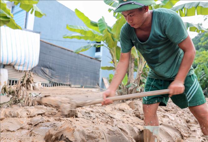 Chiến sĩ Sư đoàn 316 hỗ trợ giúp dân dọn dẹp bùn, đất do mưa lũ tại xã Phúc Khánh, huyện Bảo Yên. Ảnh: Hoàng Hiếu - TTXVN