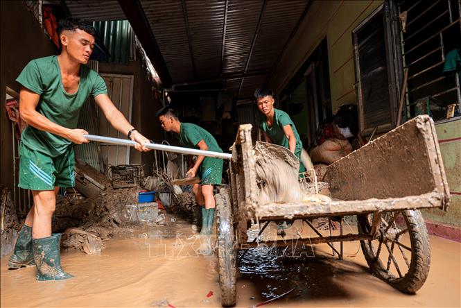Chiến sĩ Sư đoàn 316 giúp dân xã Phúc Khánh, huyện Bảo Yên dọp dẹp nhà cửa sau lũ. Ảnh: Hoàng Hiếu - TTXVN