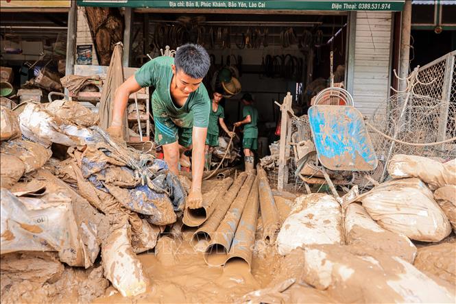 Bộ đội chung sức giúp người dân xã Phúc Khánh, huyện Bảo Yên dọn dẹp nhà cửa, phân loại hàng hoá bị hư hỏng sau trận lũ. Ảnh: Hoàng Hiếu - TTXVN