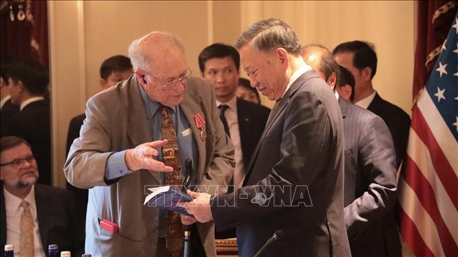 John McAuliff, Executive Director of the Fund for Reconciliation and Development, presents Vietnamese leader To Lam a book on Vietnam. VNA Photo: Thanh Tuấn
